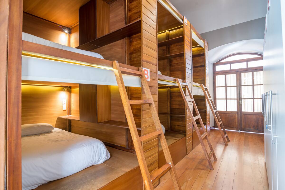 A bunk bed room with wooden walls and a ladder.