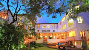 A multi-story building with a courtyard, outdoor seating, and a staircase leading to the entrance. - Viajero Quito Hostel (Quito)