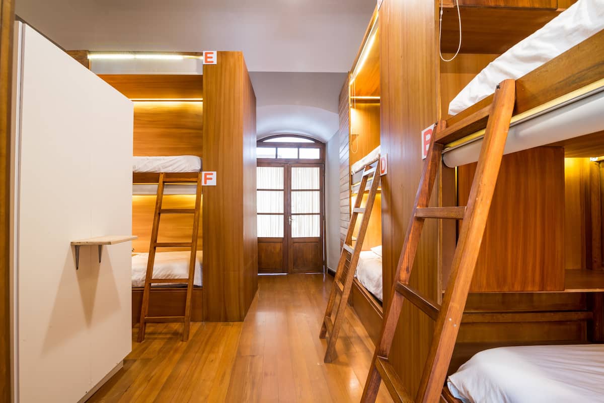 A narrow hallway with bunk beds and wooden walls.