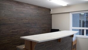 Een moderne keuken met een stenen spatwand, een wit aanrecht en een raam dat natuurlijk licht binnenlaat.
