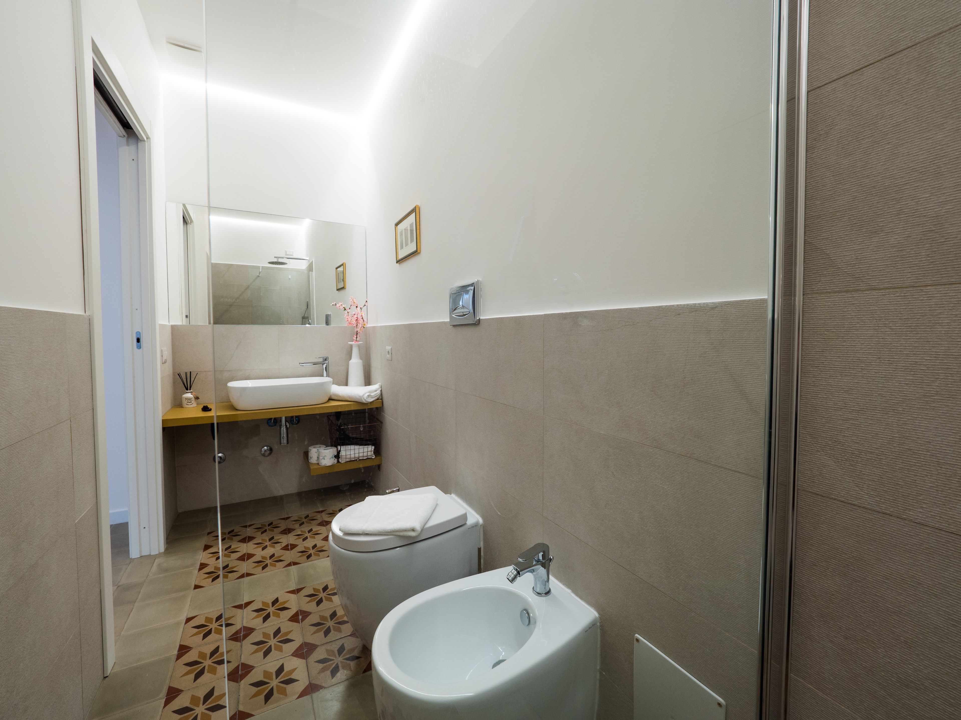 A modern bathroom with a toilet, bidet, and sink.