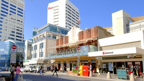 A street view with a Westfield shopping mall, National Bank, and a no entry sign. - Central Bondi Apartment New H321 (Bondi Junction)