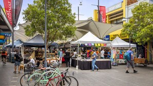 An outdoor market with various stalls and bicycles parked. - Central Bondi Apartment New H321 (Bondi Junction)