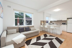 Un appartement moderne comprenant un salon, une cuisine et un coin repas.