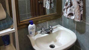 A bathroom with a white sink, a Dove lotion bottle, and a mirror above the sink. - TELA BEACH GETAWAY ☆ Apt #1 (Tela)