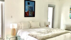 Ein geräumiges Schlafzimmer mit einem großen Bett, einem Deckenventilator und einem Bild an der Wand.
