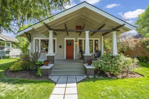 A house with a covered porch, steps leading to the front door, and a well-maintained garden. - Historic Craftsman Bungalow, Just Steps to Downtown ~HOT TUB!~ (Bend)