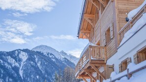 A wooden chalet with a balcony, snow-covered exterior, and a mountainous backdrop. - Chalet Grand Roi - La Tzoumaz, 4 Vallees (La Tzoumaz)