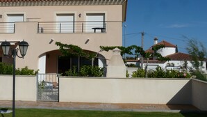 Un bâtiment à deux étages, doté d’une façade beige, d’un toit recouvert de tuiles et d’un petit balcon.