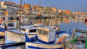 Un port de plaisance avec des bateaux amarrés, et en arrière-plan, un bâtiment surmonté d’une tour.