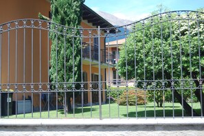 A gated area with a building featuring balconies and a garden. - House with garden a few steps from the beach and the center (Cannobio)