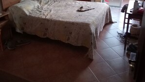 Une chambre à coucher avec un lit, une table de chevet, une chaise, une table et une vue sur l’extérieur.