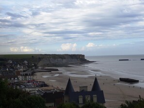 Une ville côtière avec une plage, des maisons et des falaises.