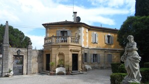 A historic building with a central courtyard, a statue, and a fountain.