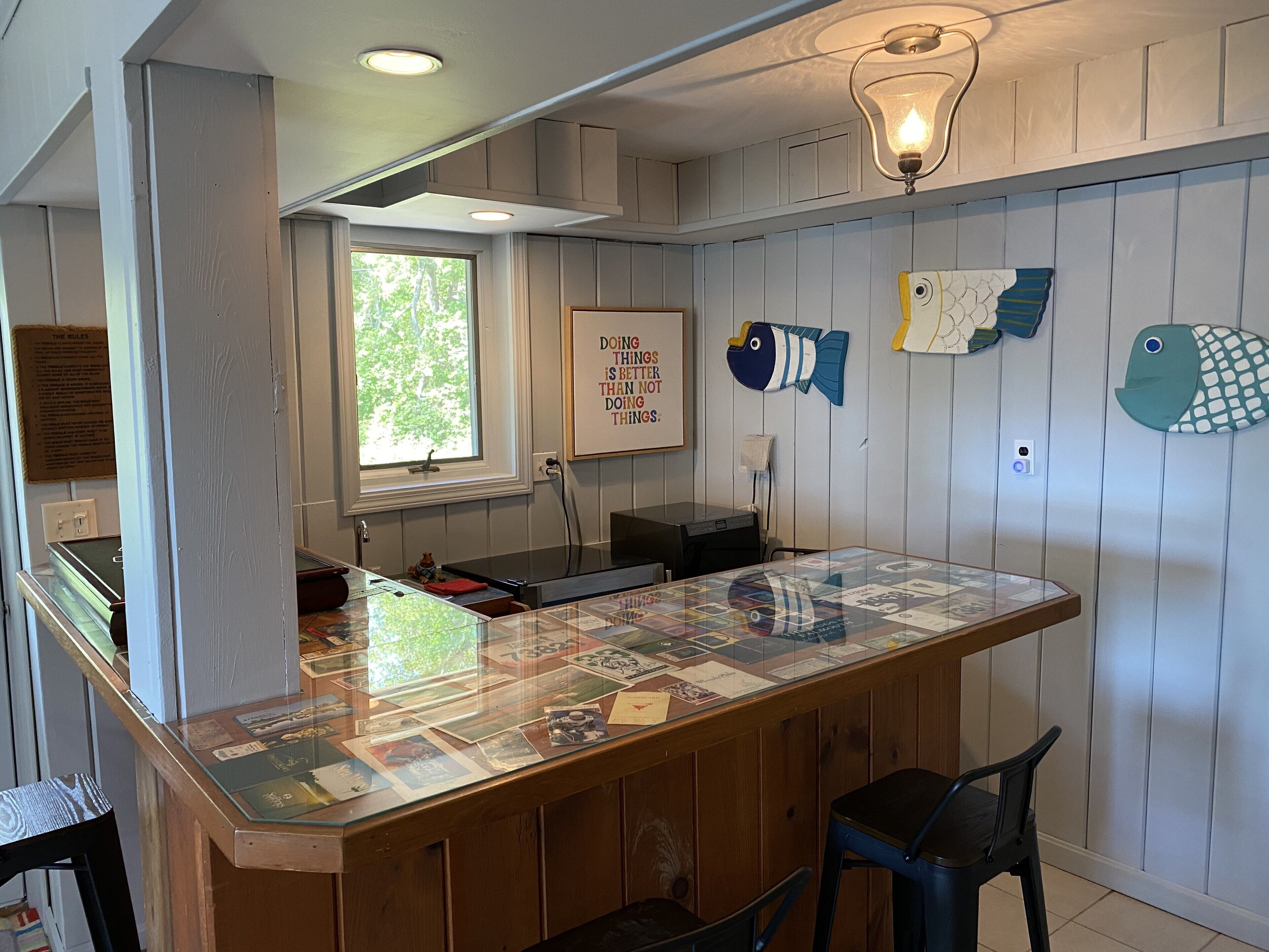 Una cocina con una isla de madera, un ventanal y decoración con motivos marinos.