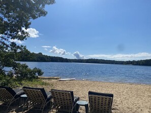 Une plage avec des chaises longues et vue sur le lac.