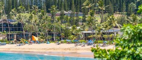 Rannalla, aurinkotuoleja, rantapyyhkeitä