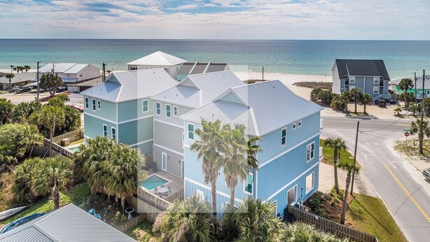 A coastal property with a swimming pool, multiple buildings, and a beach view.