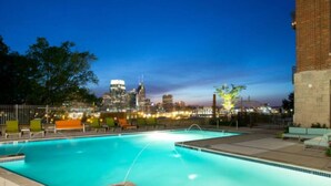 A swimming pool with a city skyline in the background.