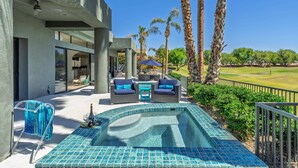A modern outdoor pool area with a hot tub, lounge chairs, and a view of a golf course. - Newly Remodeled 4,400 Square Foot Modern design with Pool and Spa. #065893 (La Quinta)