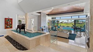 A spacious living area with a pool, a sculpture, and a view of a golf course. - Newly Remodeled 4,400 Square Foot Modern design with Pool and Spa. #065893 (La Quinta)