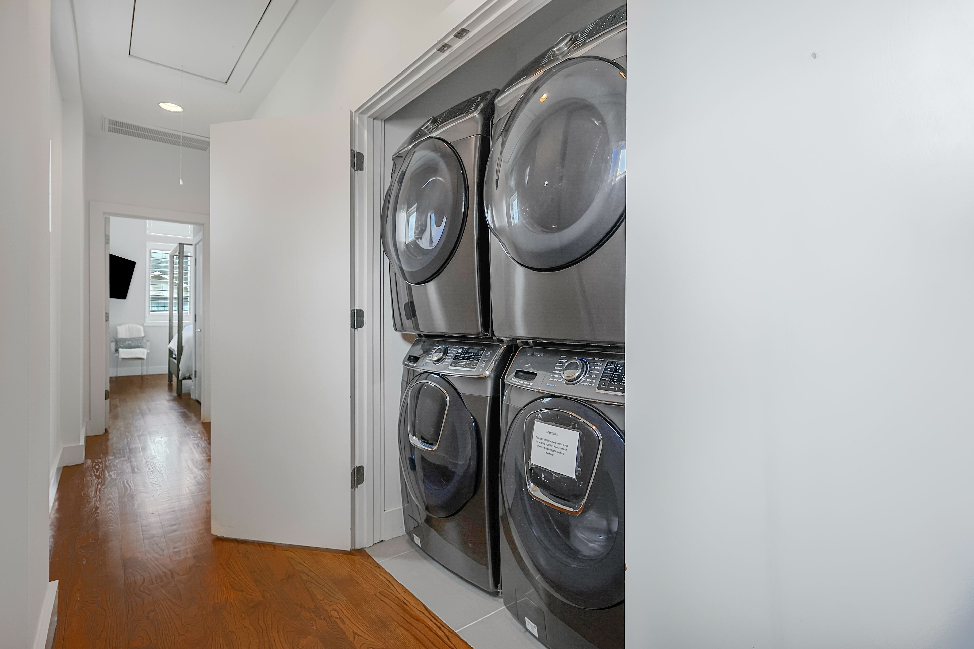 A laundry room with four stacked front-loading washing machines.