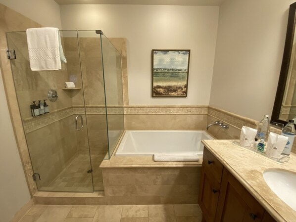 Un baño moderno con ducha de vidrio, una bañera y un lavamanos con lavabo.