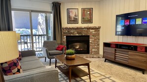 A living room with a fireplace, a television, and a sofa.