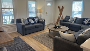 A living room with two sofas, a coffee table, and a lamp. - Sleeps 15! DOWNTOWN LAKE GENEVA Fully Licensed for Weekend Rentals! (Lake Geneva)