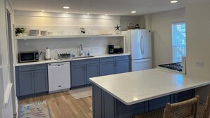 A modern kitchen with white cabinets, a built-in microwave, a dishwasher, a refrigerator, and a stove. - Sleeps 15! DOWNTOWN LAKE GENEVA Fully Licensed for Weekend Rentals! (Lake Geneva)