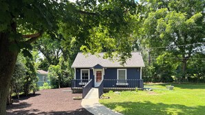 A two-story house with a front porch, a small deck, and a well-maintained lawn. - DOWNTOWN LAKE GENEVA 4 BR/4 BA House sleeps 15 (Lake Geneva)