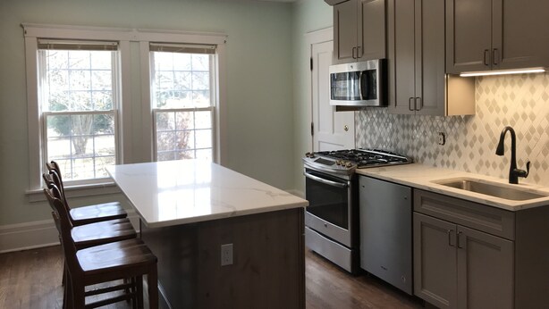 A kitchen with a central island, stainless steel appliances, and a large window. - DOWNTOWN LAKE GENEVA 4 BR/4 BA House sleeps 15 (Lake Geneva)