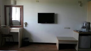 A small room with a television mounted on the wall, a desk with a chair, a small table, and a trash bin. - Light Blue (Hengchun)