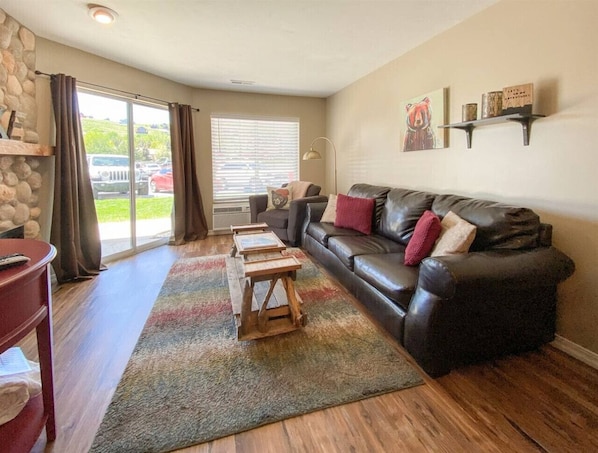 Relax in this stylish living room with a sofa, coffee table, and stone fireplace.
