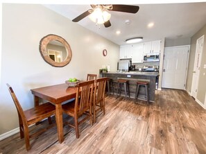 A compact kitchen with a dining table for four, complete with a microwave and refrigerator.