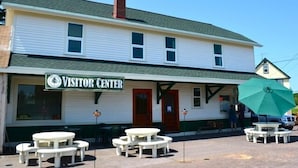 A building with a sign reading "Visitor Center" and outdoor seating with tables and benches. - Keweenaw Vacation Rental - Great for families and groups- sleeps up to 7 (Ahmeek)