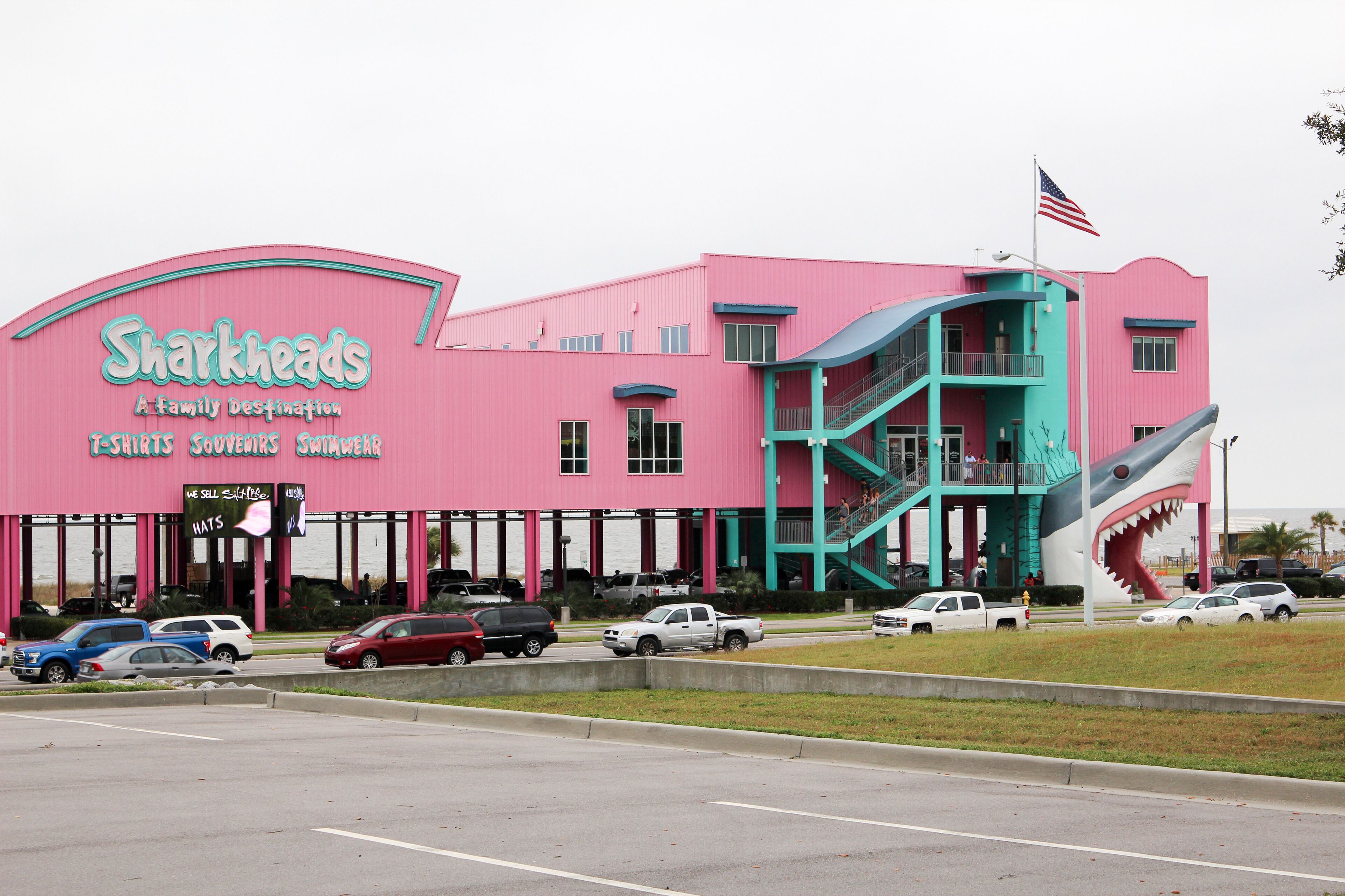 Un edificio rosa con un gráfico de tiburón y un letrero que dice 'Sharkheads'.