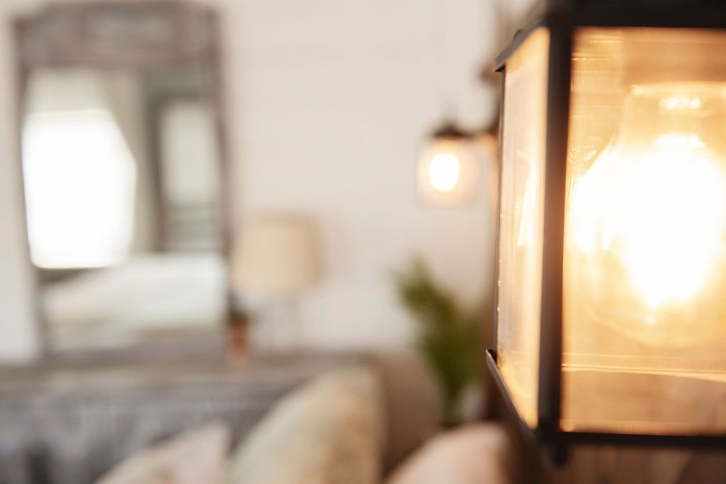 A room with a bed, a nightstand, and a lamp.