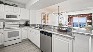 A modern kitchen with white cabinetry, a built-in oven, microwave, and dishwasher. - Last Minute Rate, Direct Oceanfront 4BR/3BA, Sleep 16, Central Location (Myrtle Beach)