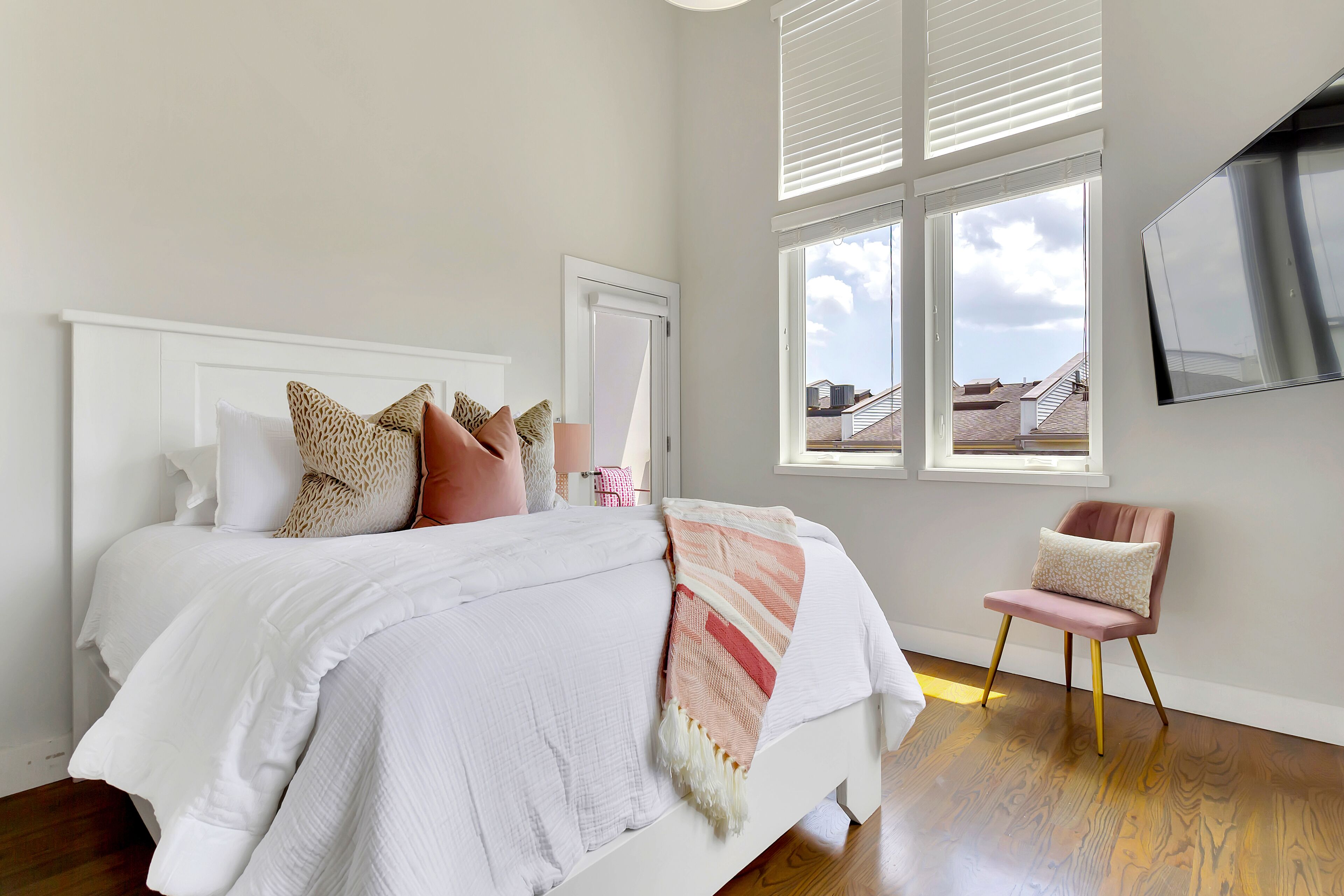 Un dormitorio con una cama, una silla y una ventana con persianas.