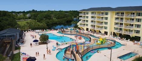 Un resort con varias piscinas, un tobogán de agua y un edificio grande con balcones.