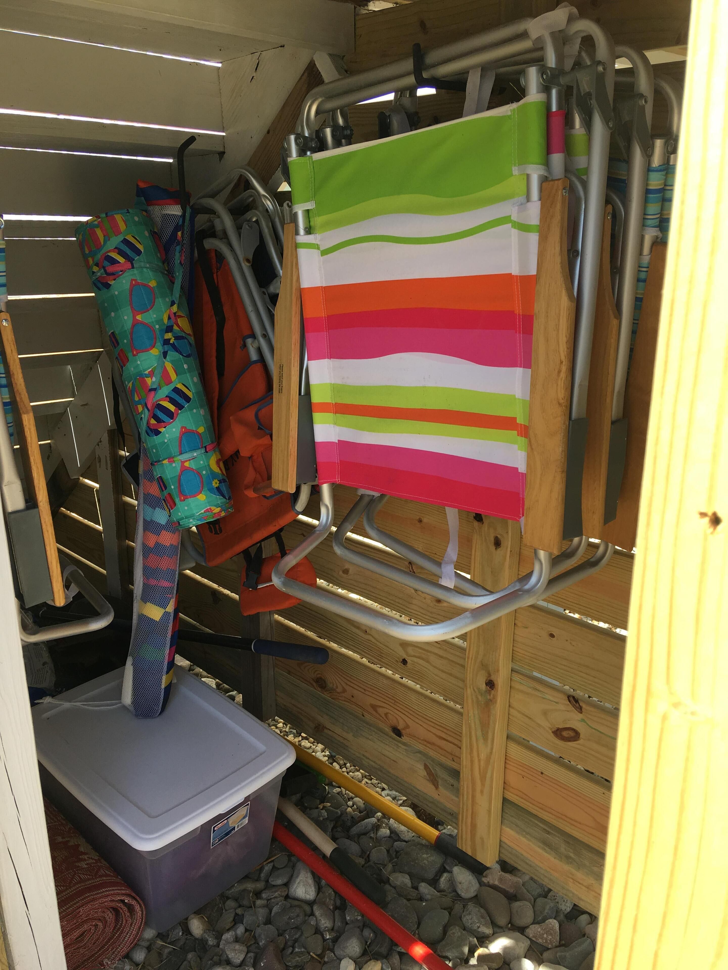 A storage area with shelves, a bench, and a colorful striped bag hanging on a rack.