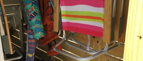 A storage area with shelves, a bench, and a colorful striped bag hanging on a rack.