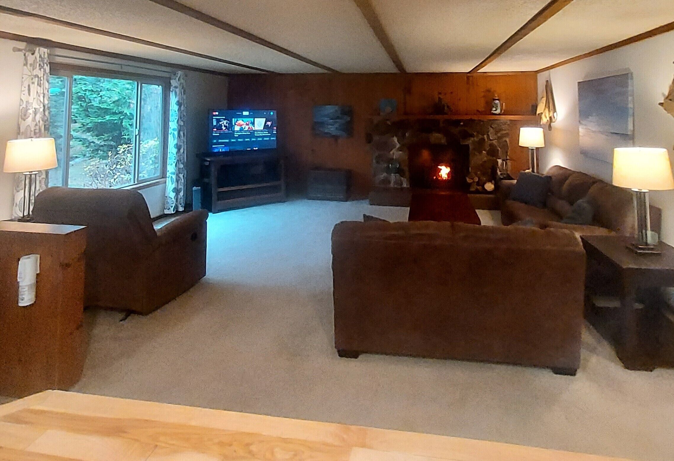 A cozy living room with a fireplace, comfortable seating, and a television.