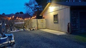 A gravel driveway leading to a wooden building with a sign reading "Erazor's Edge."