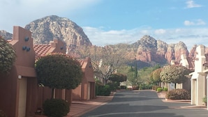 A street lined with buildings featuring terracotta roofs and stucco walls, leading towards a mountainous backdrop. - Little taste of Heaven, 5 min walk to pool/hot tub, close to hikes & restaurants (Sedona)
