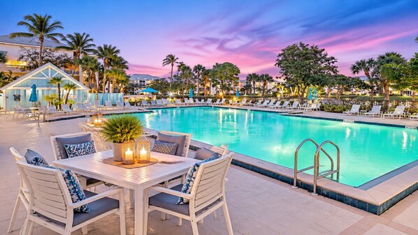 A poolside area with lounge chairs and a table with candles.