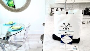 A modern kitchen with a glass table, clear chairs, and a white countertop. - POSHPADZ-Playa Blanca-Walk to Jupiter Beach-Balcony with Seating & Dining Area (Jupiter)