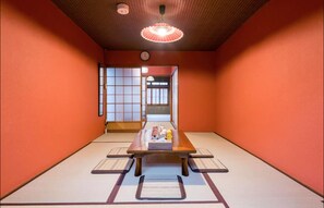 A traditional tatami room with a low table, cushions, and sliding doors.