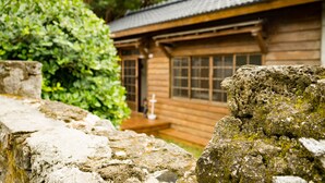 A traditional wooden building with a tiled roof, surrounded by lush greenery. - 22alleys (Magong)